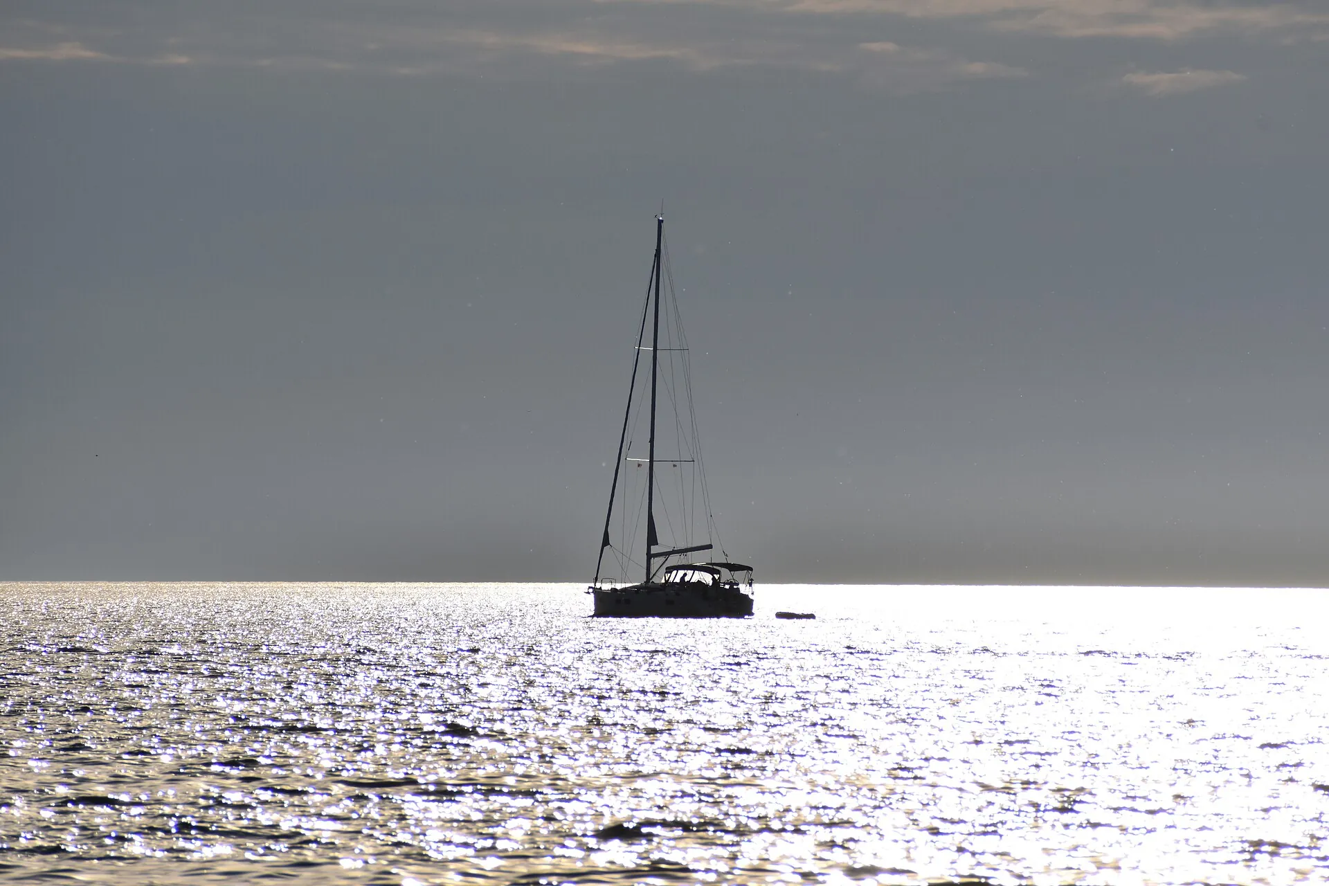 A sailing boat silhouetted on a glittering Adriatic sea